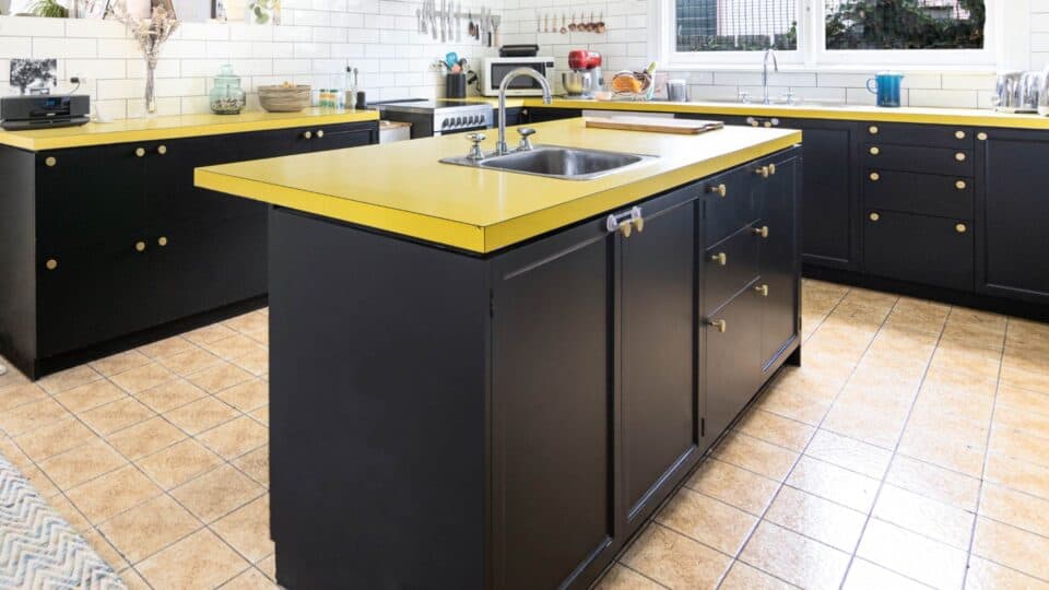 Dark black kitchen cabinets with yellow green color counter tops.