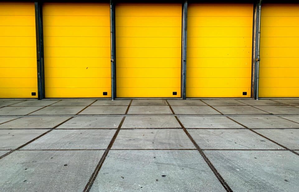 paved flooring leading to bright yellow shutter doors