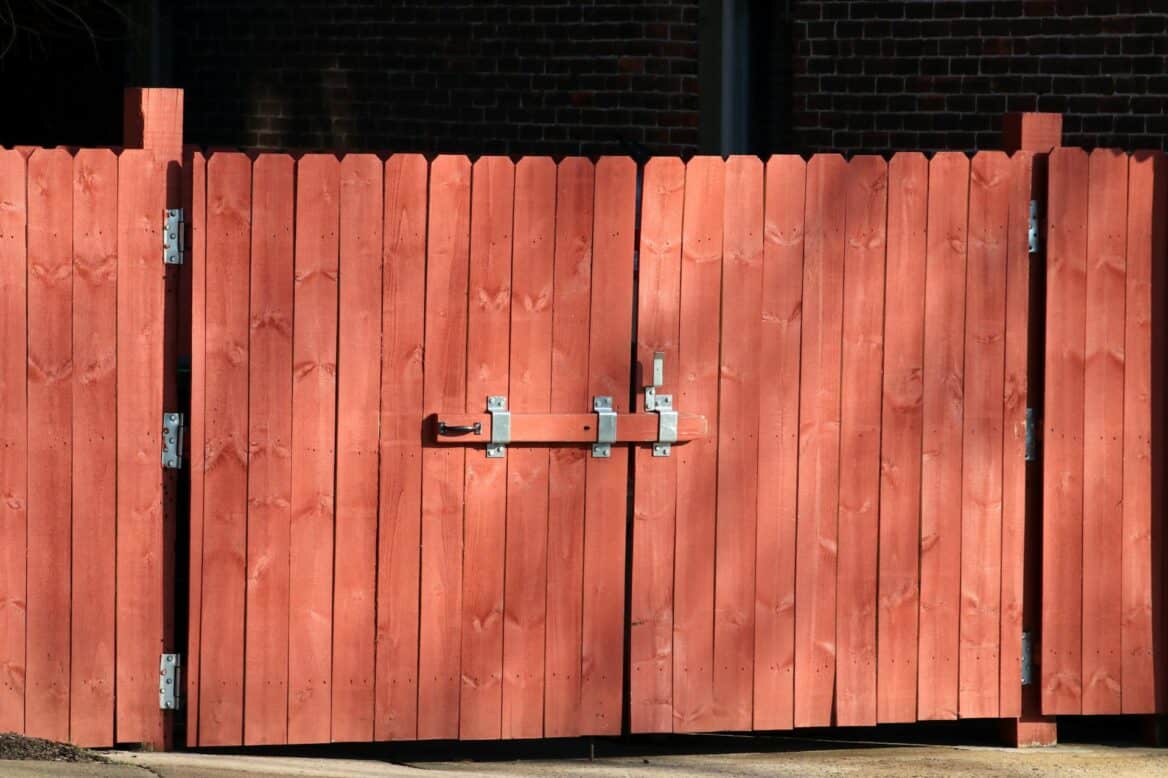 A red wood stained fence and gate.