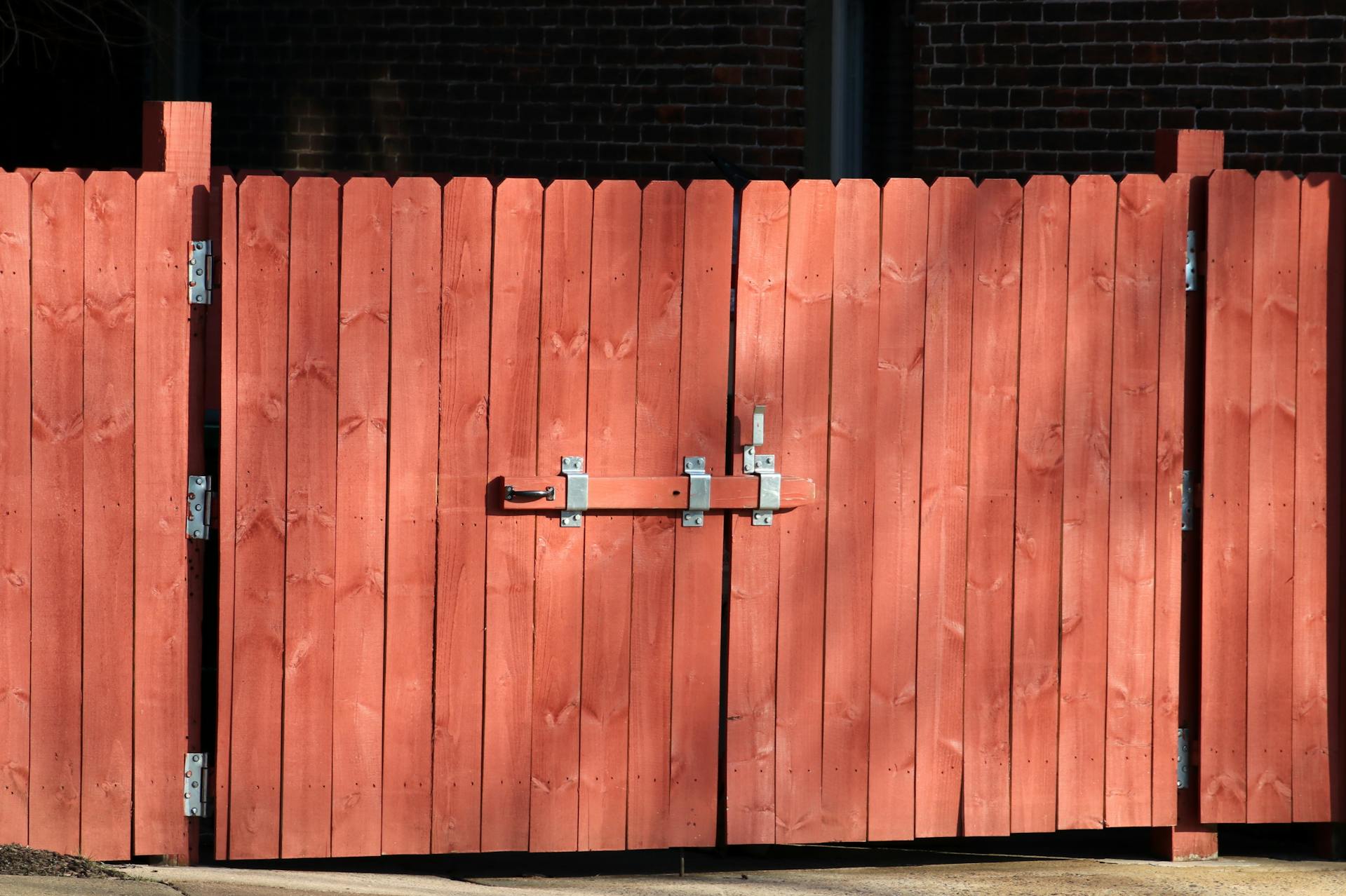A red wood stained fence and gate.