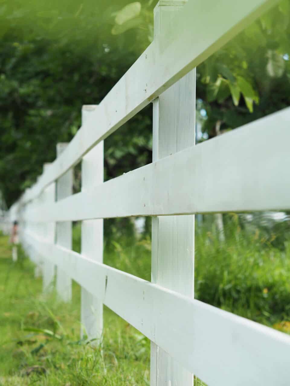 white wooden painted fence along green grass