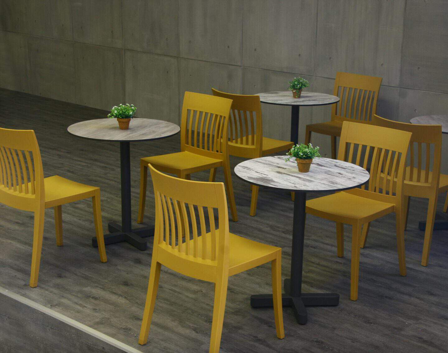 Yellow painted chairs sitting at small bistro tables.